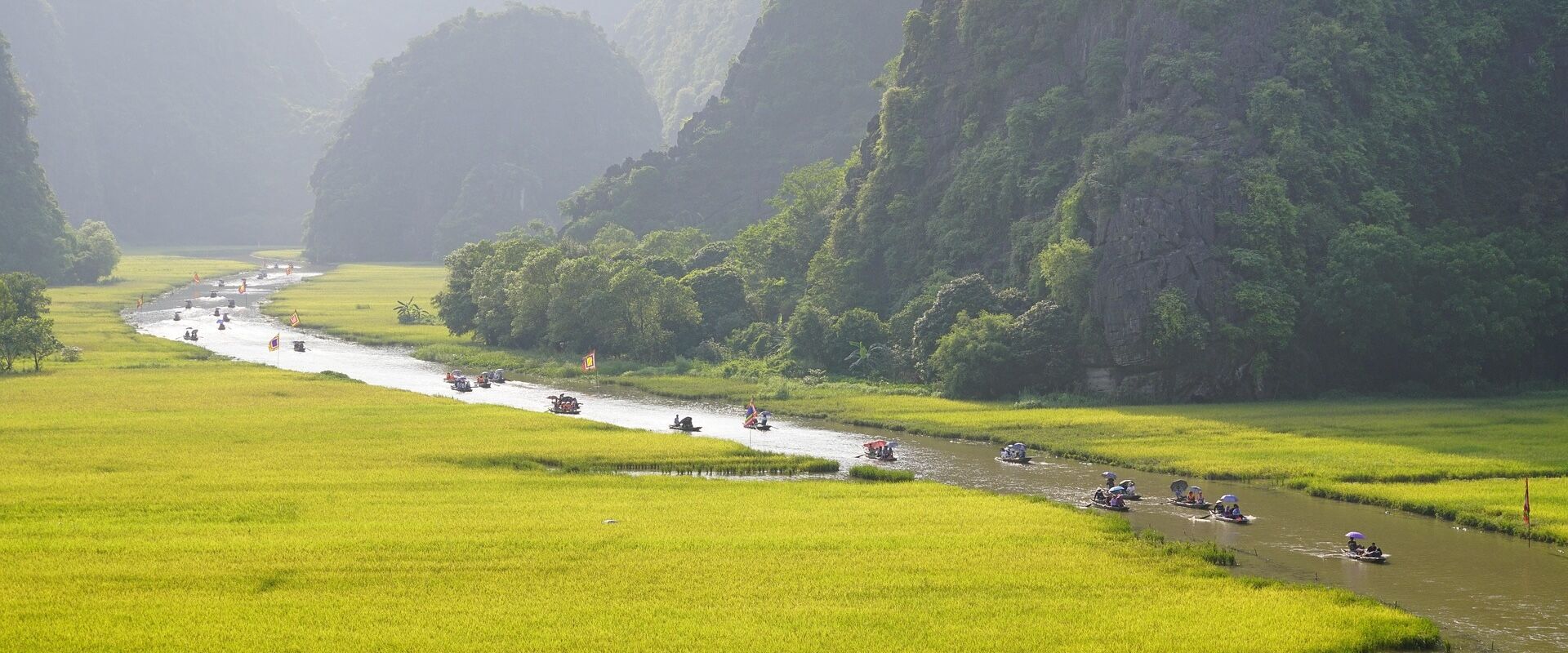 Tourists rowing through Tam Coc’s caves on a Tam Coc Tours journey with Legend Travel Group.